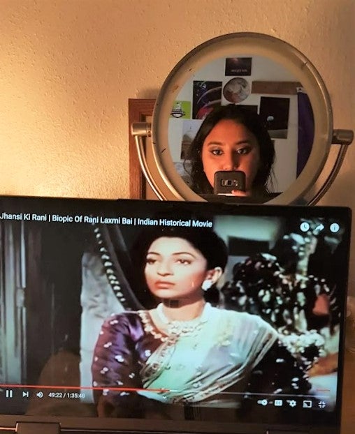 A video clip playing on a computer with a woman taking a selfie in the mirror