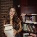 Young woman holding stack of books